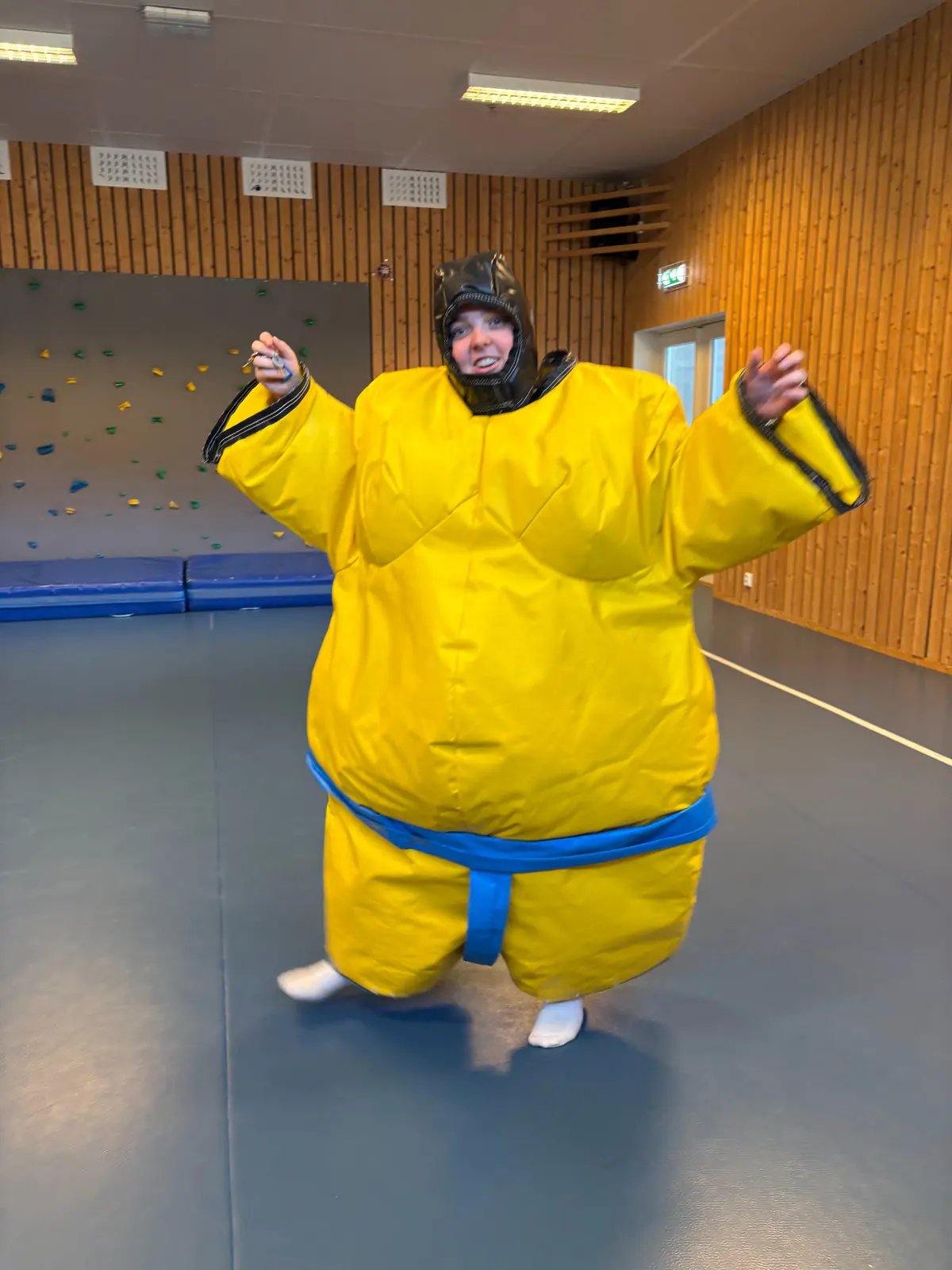 Deltaker i oppblåsbar sumodrakt i gymsalen